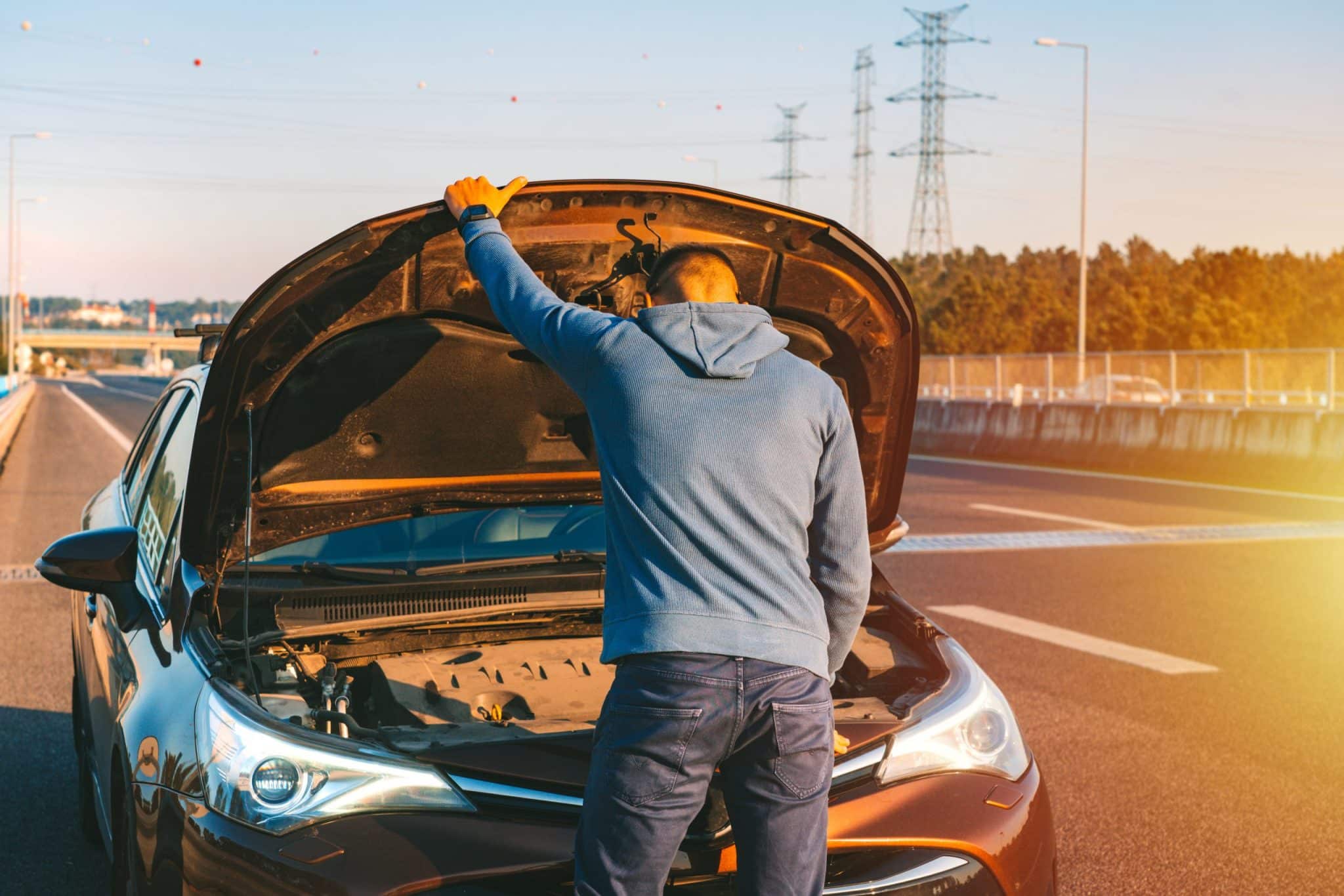 Vyras atidares automobilio kapota